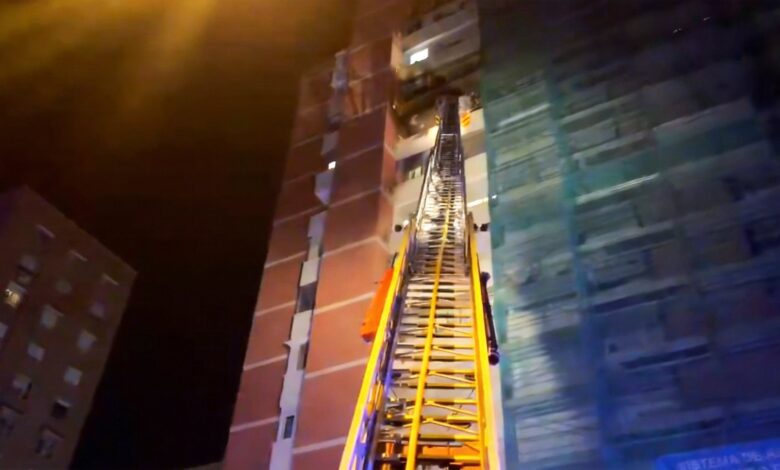 Police Officer Shelters Woman During Apartment Fire in Madrid